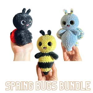 May include: A set of three crocheted plush toys: a ladybug, a bee, and a butterfly. The ladybug is red and black, the bee is yellow and black, and the butterfly is blue with green and white accents. The toys all have a happy expression.