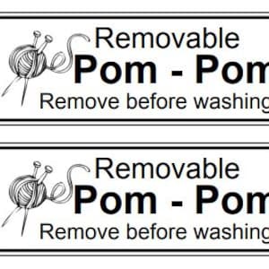 May include: Two black and white labels with a drawing of a yarn ball and knitting needles. The text on the labels reads "Removable Pom - Pom Remove before washing."