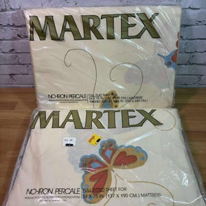 May include: Two packages of Martex full flat sheets. The sheets are cream-colored with a butterfly design in shades of blue, red, and gold. The packaging includes the text "Martex" and "No-Iron Percale" and are for a 54 x 75 in. (137 x 190 cm.) mattress.