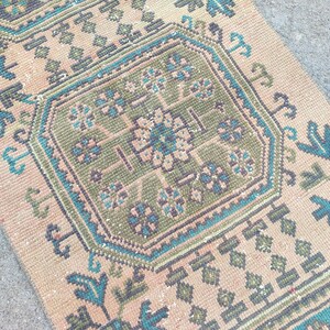 May include: A vintage Turkish runner rug with a beige background and intricate geometric patterns in shades of green, blue, and brown.