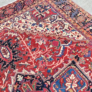 May include: A red, blue, and white Persian rug with a floral pattern. The rug has a central medallion and a border with intricate designs.