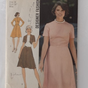 May include: Simplicity sewing pattern 6145, size 14, bust 36 inches. The cover features illustrations of dresses and a woman in a pink dress. The text reads "Designer Fashion" and "K-Grics".