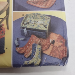 May include: A sewing pattern with instructions for making a variety of small items, including a chair, a boot, a glasses case, and a small bag. The pattern is printed on a blue background with white text.