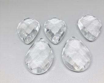 May include: Five clear crystal teardrop-shaped pendants with faceted surfaces.