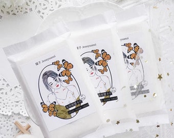 Puede incluir: Un paquete de 20 tarjetas de notas para chicas con una ilustración de acuarela de una mujer con mariposas. Las tarjetas están empaquetadas en un sobre blanco con el texto "Girl note card" y "20 PCS" impreso en el frente.