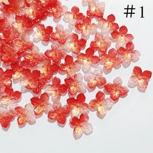 Peut inclure: Une dispersion de décorations en résine en forme de fleurs rouges et blanches avec un reflet doré.  #1