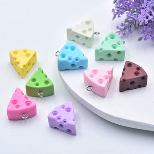 Puede incluir: Surtido de nueve abalorios con forma de queso de colores con un agujero para colgar. Los abalorios son de varios colores, incluyendo amarillo, verde, azul, rosa, morado, blanco y marrón.