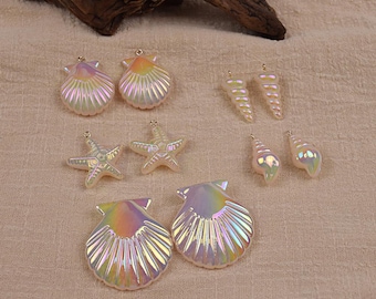May include: Iridescent seashell and starfish charms. The charms include two large scallop shells, two smaller scallop shells, two starfish, and four conch shell charms. The charms have a pearlescent finish with a rainbow sheen.