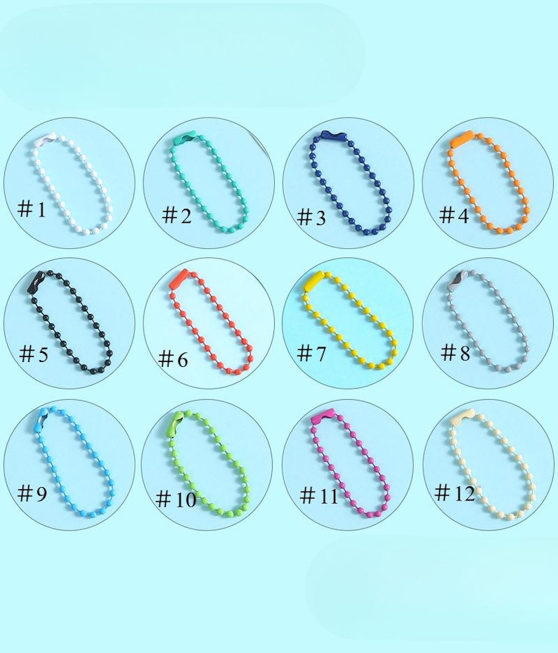 May include: A collection of twelve ball chain keychains in various colors, including white, teal, navy, orange, black, red, yellow, gray, light blue, green, pink, and cream. Each keychain is labeled with a number from #1 to #12.