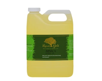 May include: A large, yellow plastic jug of Liquid Gold Arnica Herbal Oil. The label features a gold tree illustration and green accents. Text on the label indicates the oil is 100% pure organic for hair, skin, and body, and multi-purpose.