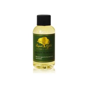 Puede incluir: Una botella de vidrio transparente con una tapa negra llena de un l&iacute;quido amarillo claro. La botella tiene una etiqueta verde con letras doradas que dicen "Liquid Gold The Academy of Organic Oils Sweet Almond Oil 100% pure organic for hair skin & body multi purpose".