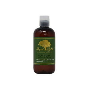 May include: A brown bottle of Liquid Gold Flax Seed Oil Unrefined. The bottle has a green label with a gold tree and the text "Liquid Gold The Academy of Organic Oils Flax Seed Oil Unrefined 100% pure organic for hair skin & body multi purpose".