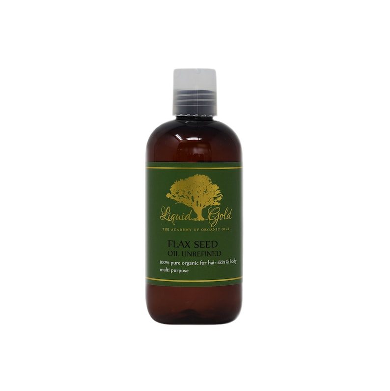May include: A brown bottle of Liquid Gold Flax Seed Oil Unrefined. The bottle has a green label with a gold tree and the text "Liquid Gold The Academy of Organic Oils Flax Seed Oil Unrefined 100% pure organic for hair skin & body multi purpose".