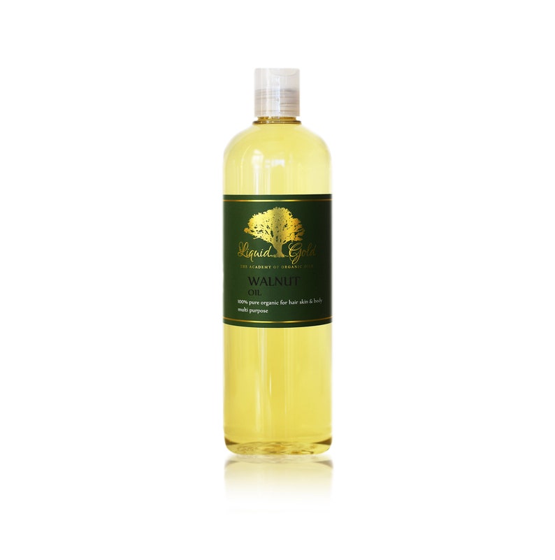 Pode incluir: Uma garrafa de vidro transparente com uma tampa dourada cheia de l&iacute;quido amarelo. A garrafa tem um r&oacute;tulo verde com letras douradas que dizem "Liquid Gold The Academy of Organics Walnut Oil 100% pure organic for hair skin & body multi purpose".