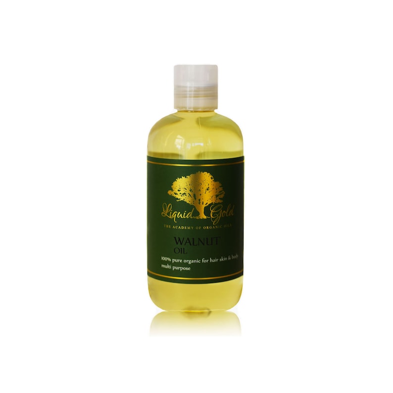 Pode incluir: Uma garrafa de vidro transparente com um r&oacute;tulo dourado que diz "Liquid Gold The Academy of Organic Oils Walnut Oil 100% pure organic for hair skin & body multi purpose". A garrafa est&aacute; cheia de um l&iacute;quido amarelo claro.