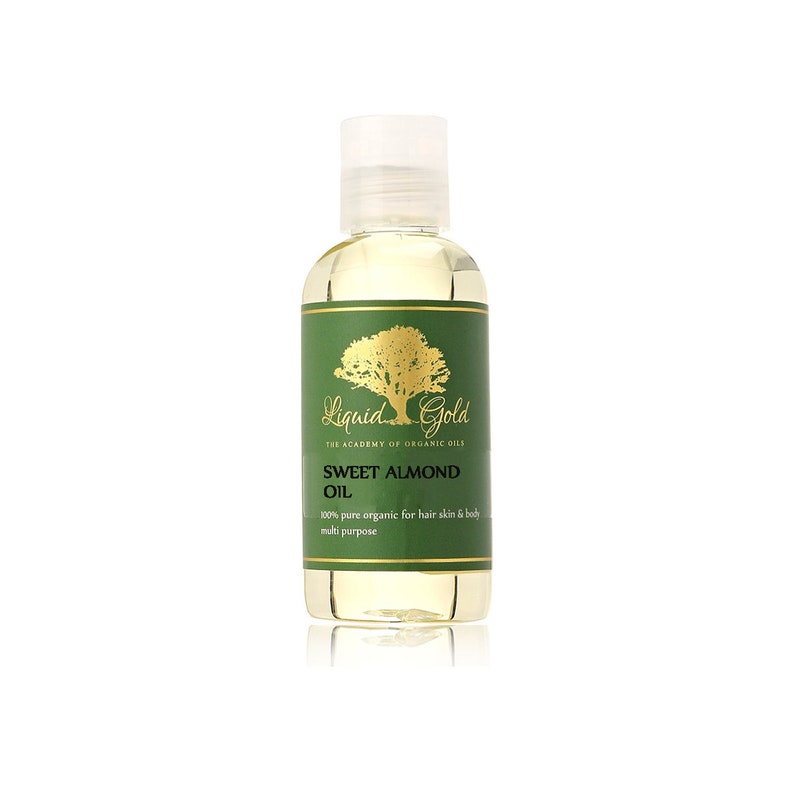 Puede incluir: Una botella de vidrio transparente con una etiqueta dorada que dice "Liquid Gold The Academy of Organic Oils Sweet Almond Oil 100% pure organic for hair skin & body multi purpose".