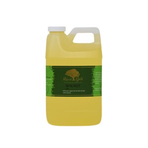 Pode incluir: Um gal&atilde;o de &oacute;leo de noz de Liquid Gold. O r&oacute;tulo &eacute; verde e dourado com um logotipo de &aacute;rvore e o texto "Liquid Gold The Alchemy of Ireland Oil Walnut Oil 100% pure organic for hair skin & body multi purpose".