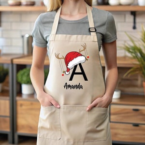 a woman wearing an apron with a santa hat on it
