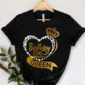 May include: Black t-shirt with a gold heart design featuring a crown, pearls, and the text "Birthday Queen".