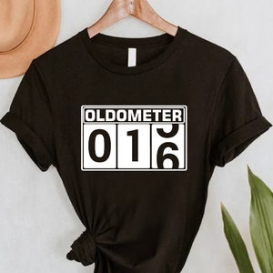 May include: Black t-shirt with a white graphic that says "Oldometer 016".