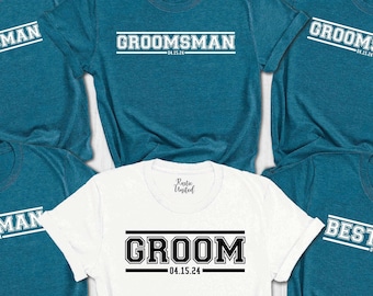May include: Five teal blue t-shirts with white text that reads "Best Man" and "Groomsman" and one white t-shirt with black text that reads "Groom". The date "04.15.24" is printed on each shirt.