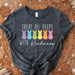 May include: A dark grey t-shirt with the text "Treat all peeps with kindness" and a row of colourful marshmallow peeps.