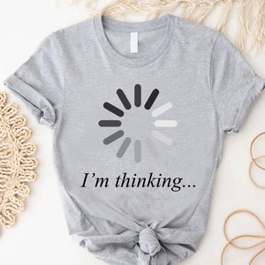 May include: A gray t-shirt with a black and white loading icon and the text "I'm thinking..." printed on the front.