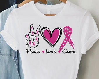 May include: White t-shirt with a pink peace sign, heart, and ribbon with the text "Peace Love Cure".
