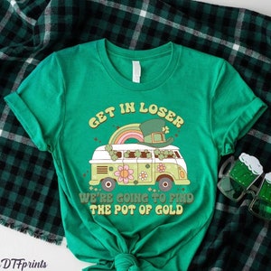May include: Green t-shirt with a retro-style graphic of a van with a leprechaun on top. The text on the shirt reads "Get in Loser We're going to find the pot of gold".