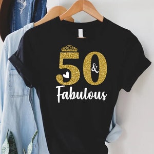 May include: Black t-shirt with gold glitter "50 & Fabulous" text and a small white heart.