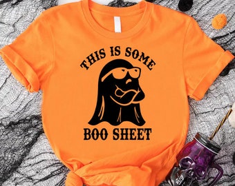 May include: Orange t-shirt with a black ghost wearing sunglasses and the text "This is some boo sheet".