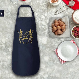 a navy blue chef's apron next to a bowl of eggs and other ingredients
