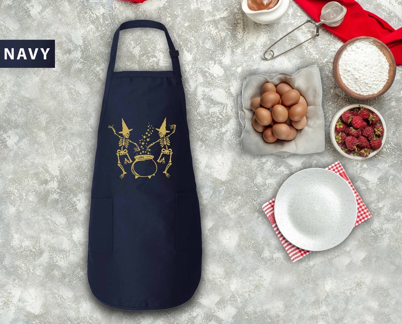 a navy blue chef's apron next to a bowl of eggs and other ingredients