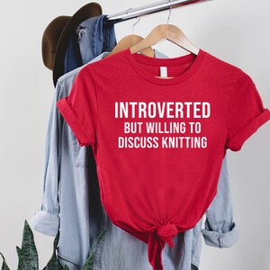 a t - shirt that says, interrupted but willing to discuss knitting