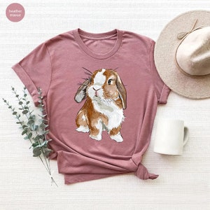 a pink shirt with a brown and white rabbit on it
