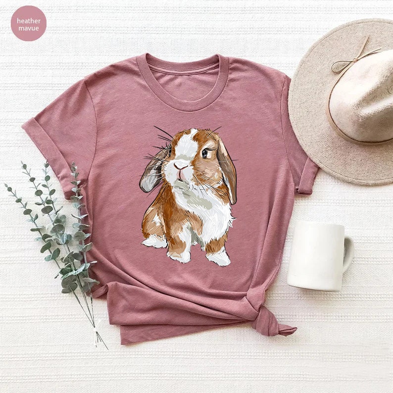 a pink shirt with a brown and white rabbit on it