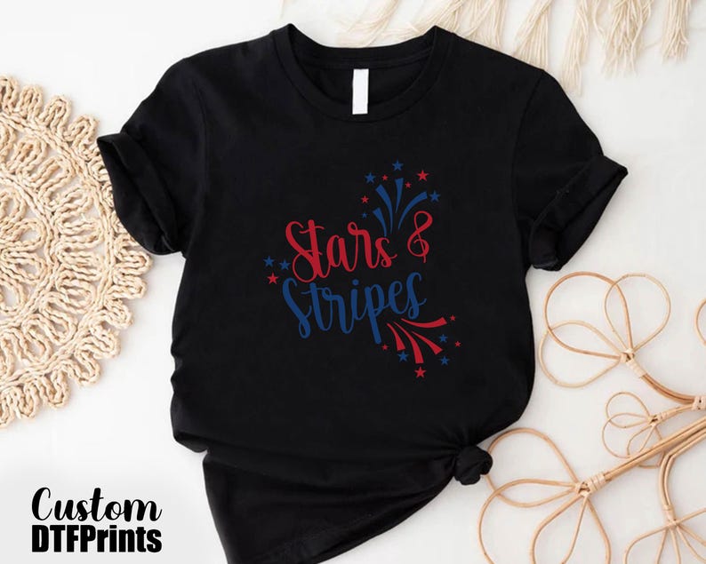 May include: Black t-shirt with red and blue text that says "Stars & Stripes" with a firework design.