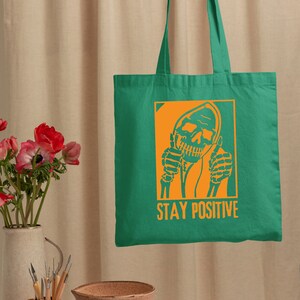a person holding a green bag with a skull on it