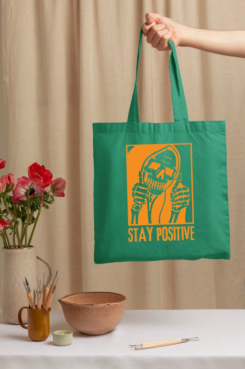 a person holding a green bag with a skull on it