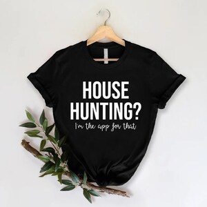 May include: Black t-shirt with white text that reads "HOUSE HUNTING? I'm the app for that."