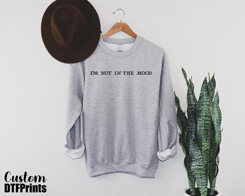 a hat and a sweatshirt hanging on a wall