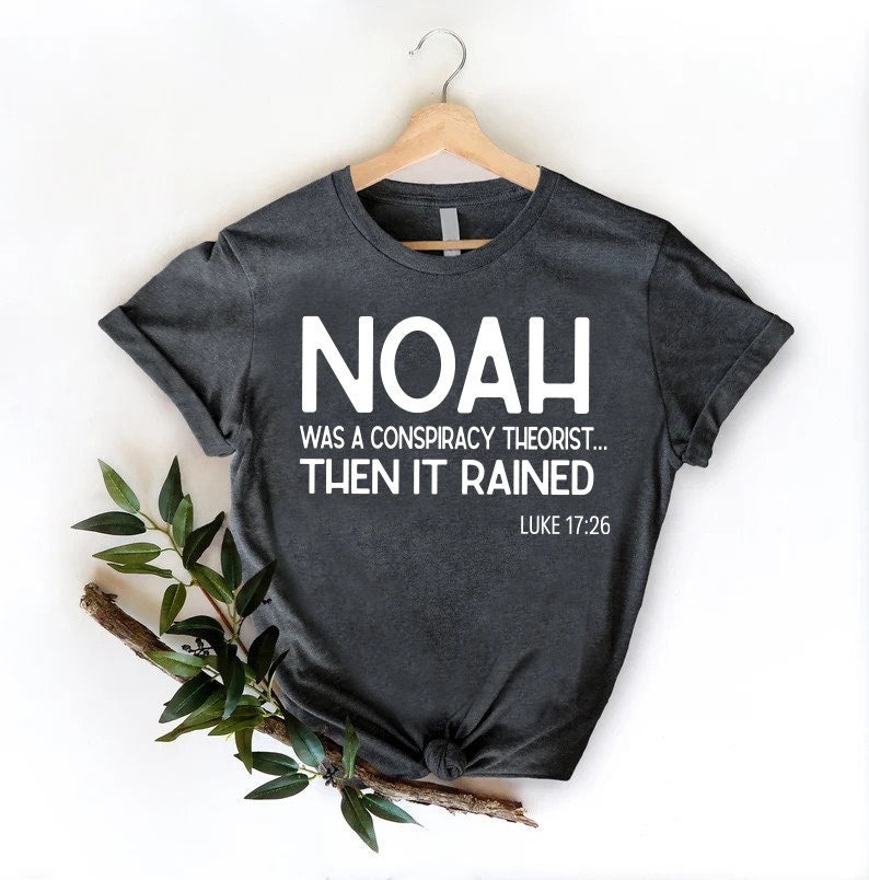 Puede incluir: Una camiseta gris oscuro con texto blanco que dice "No&eacute; fue un te&oacute;rico de la conspiraci&oacute;n... luego llovi&oacute;. Lucas 17:26".