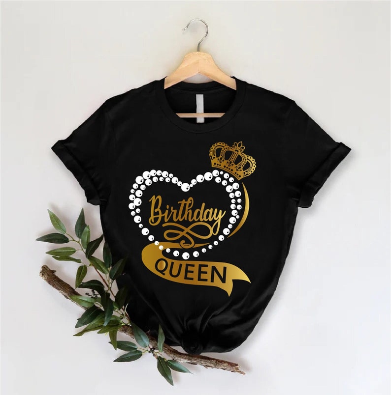 May include: Black t-shirt with a gold heart design featuring a crown, pearls, and the text "Birthday Queen".