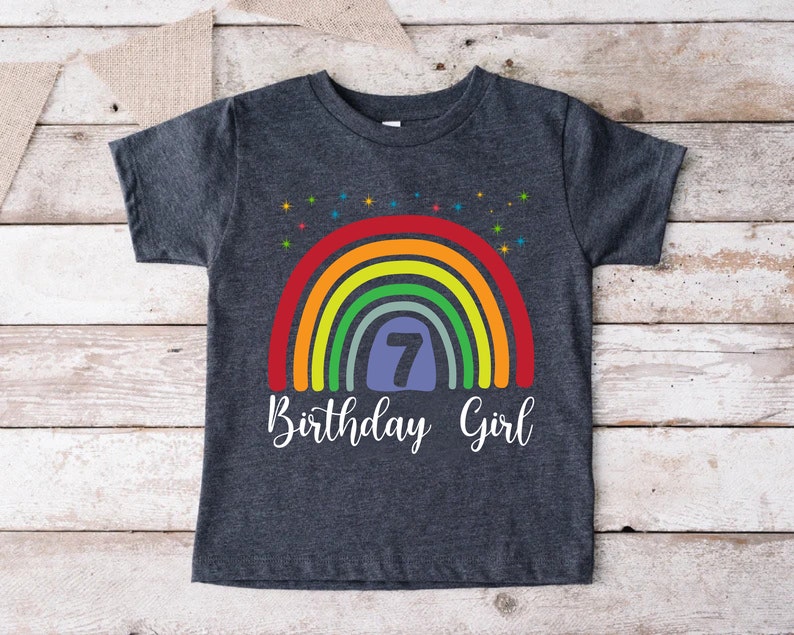 Peut inclure: Un t-shirt gris fonc&eacute; avec un motif arc-en-ciel et le texte "7 Birthday Girl".
