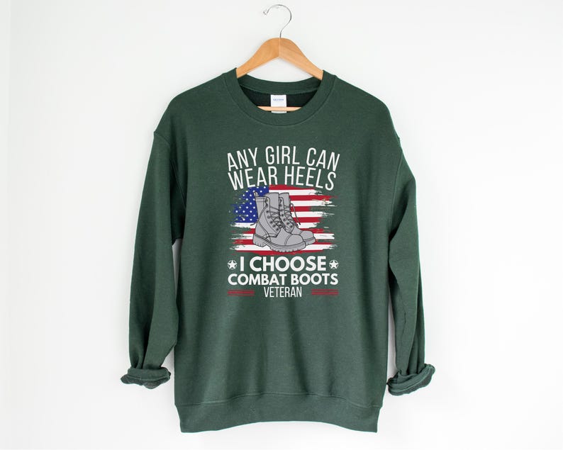 May include: Green sweatshirt with the text "Any girl can wear heels * I choose combat boots * Veteran" and a graphic of a pair of combat boots on an American flag.
