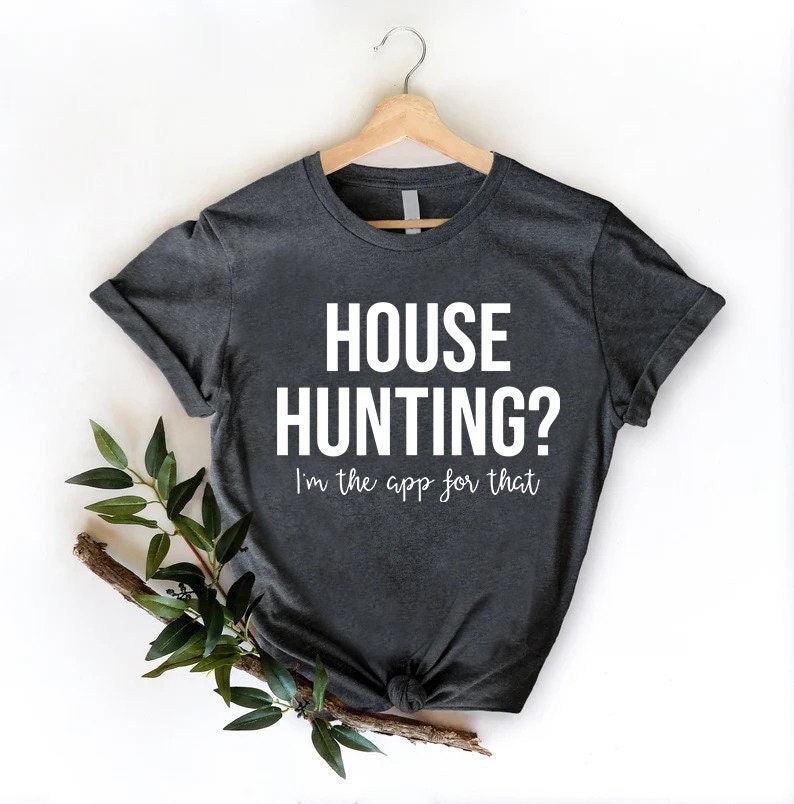 May include: A dark gray t-shirt with the text "HOUSE HUNTING? I'm the app for that" printed in white.