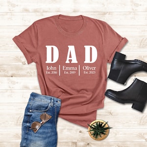 a t - shirt that says dad and a pair of jeans