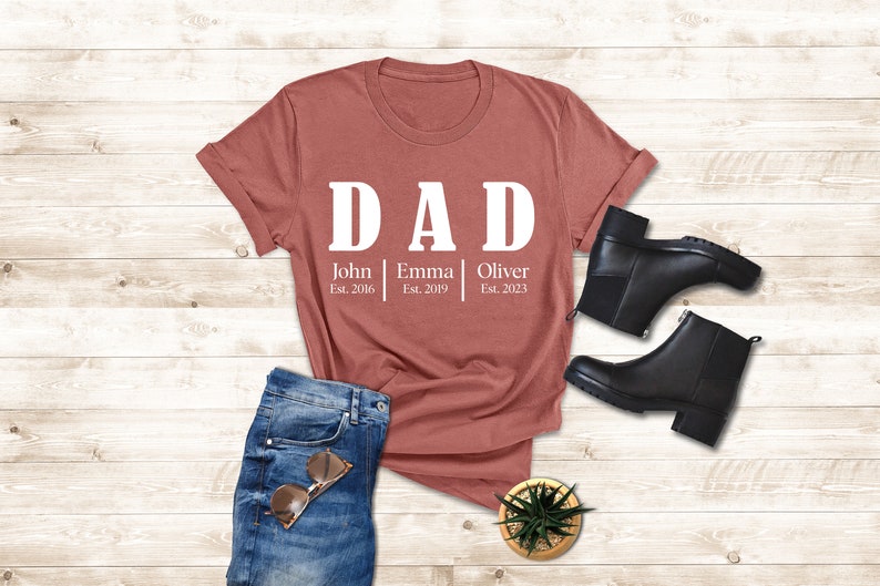 a t - shirt that says dad and a pair of jeans