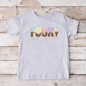 K&ouml;nnte beinhalten: Ein graues T-Shirt mit kurzen &Auml;rmeln mit dem Wort "FOUR" in bunten Buchstaben mit Eiswaffel-Designs. Der Text "ever sweet" steht unter dem Wort "FOUR".