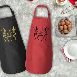 two red and black cooking aprons next to a bowl of eggs